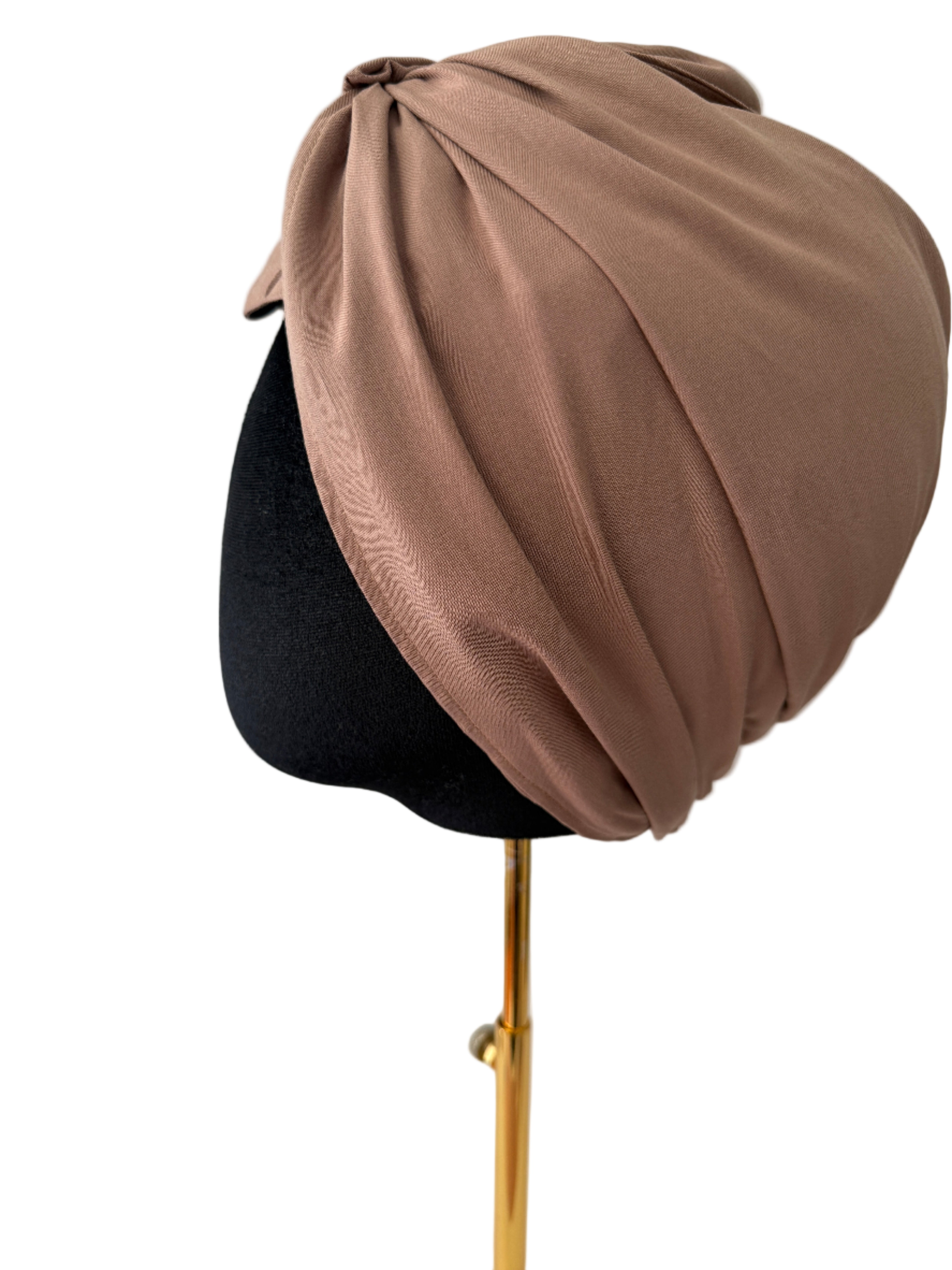 Brown turban on a mannequin head against a white background